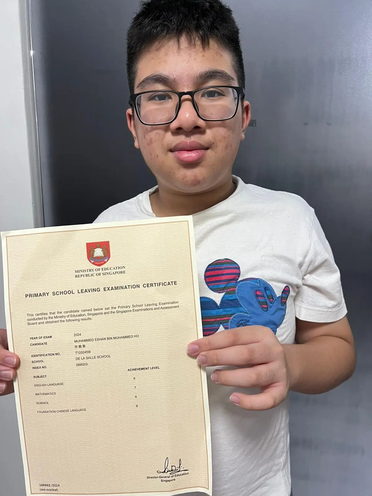Primary student smiling while holding up a certificate